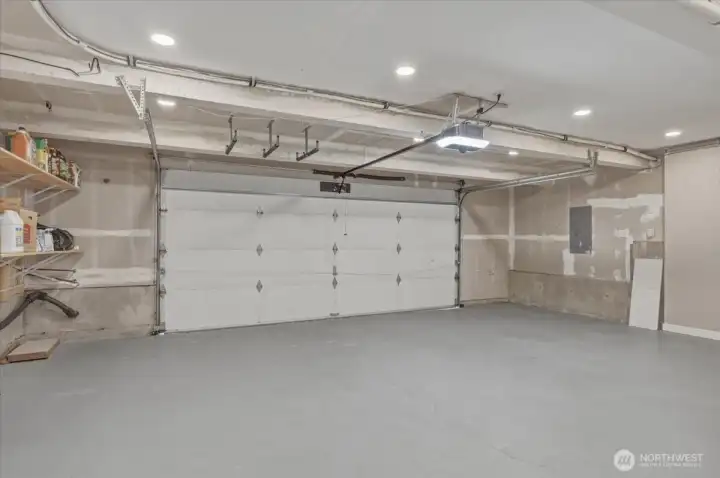 Extra-wide two car garage featuring storage shelving and an ultra-quiet garage door opener.