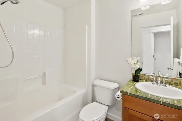 A bright and clean full spare bathroom that feels airy and welcoming for others.