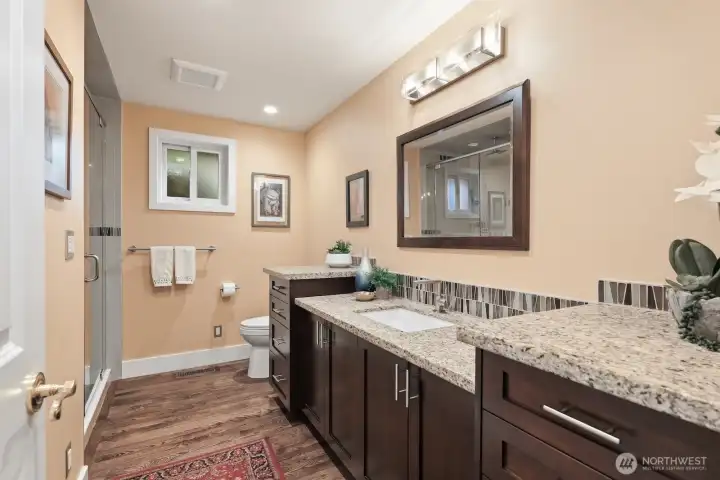 Updated main level guest bath with granite countertops and hardwood floors and cabinets and rain shower.