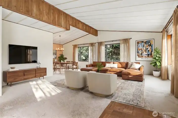Living room with vaulted ceilings and picture window with a lake view opens to the dining room.  Virtually staged photo.