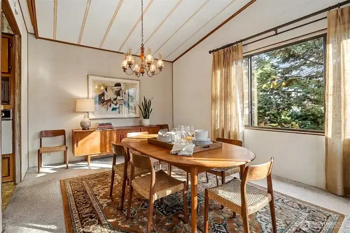 Formal dining room with vaulted ceilings, opens to the living room overlooking the lake.   Virtually staged photo