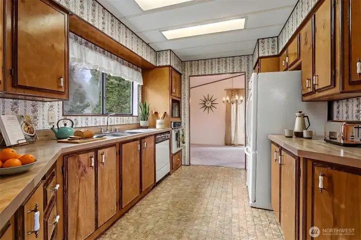 Spacious kitchen with plenty of counter and cabinet space and an eating bar opens to the family room.  Virtually staged photo