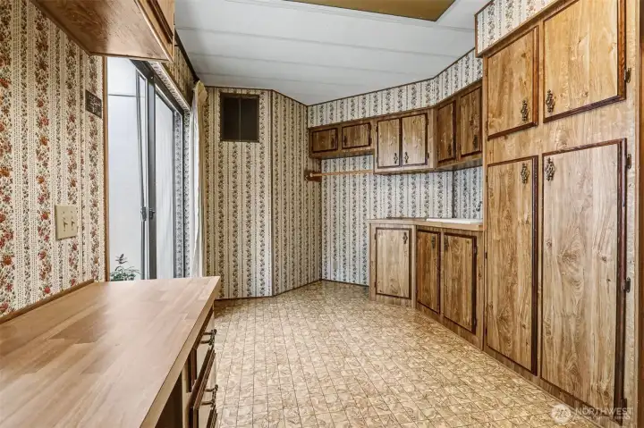 Huge utility room with full size washer and dryer, a utility sink and cabinets and counterspace galore. Opens to the atrium/greenhouse