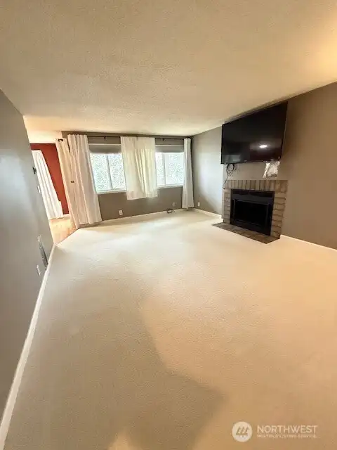 Windows look out to the covered patio and nature