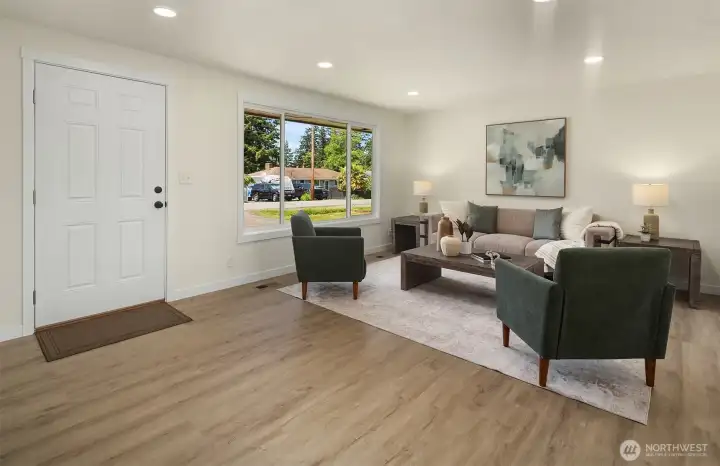 Front entry leads into living room with large windows bringing in ample natural light.