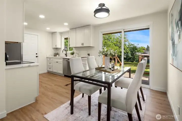 Eating space off of kitchen with sliding doors leading to deck overlooking the backyard.