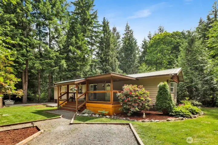 Inviting front exterior featuring a covered porch, mature landscaping, and excellent curb appeal.