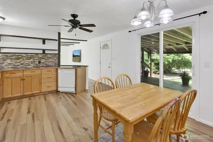Dining area overlooking the deck and surrounding greenery.