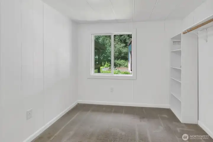 Second bedroom featuring natural light, built-in shelving, and flexible use options.