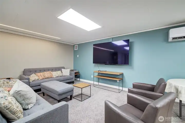 Community room has tables and chairs for parties and also this seating area for hosting an Oscar night or Super Bowl viewing.