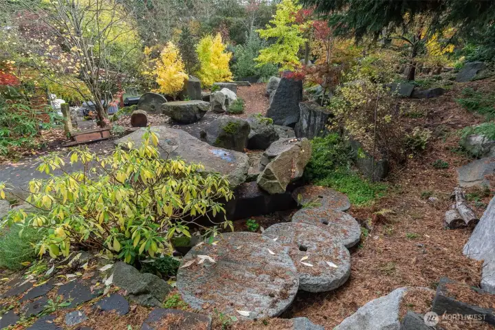 Giant Antique Millstones create steps to a potential patio area at rear of house.