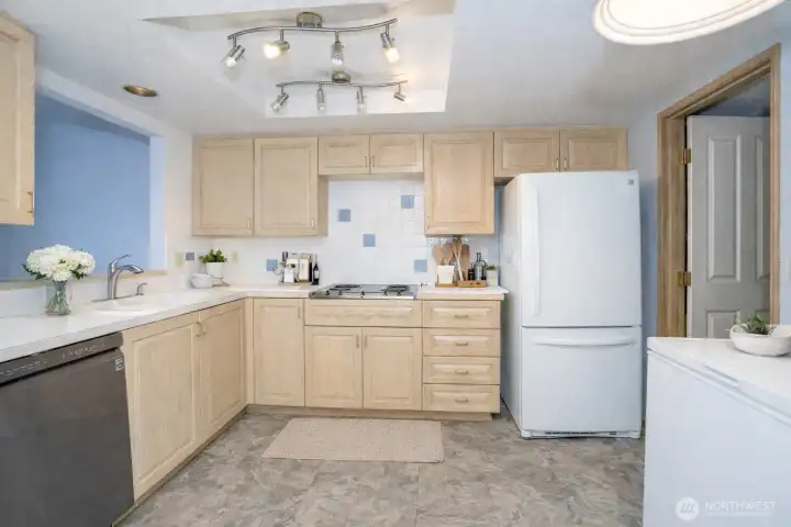 Additional kitchen perspective featuring stunning cabinets and access to the utility room with a handy utility sink.
