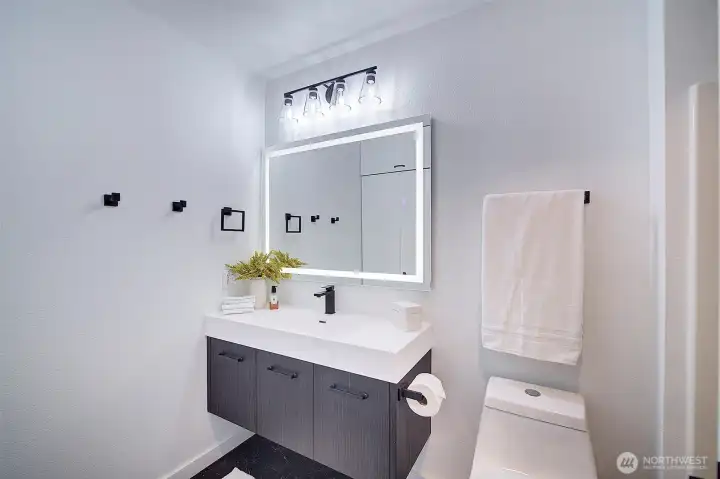 Updated bathroom with LED lit mirror and floating vanity.