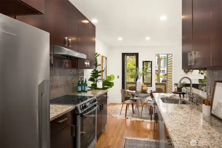 Kitchen flows seamlessly between entry, dining, and licing areas.