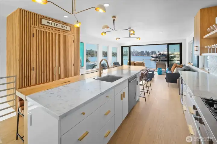 Open-concept kitchen & living space anchored by a striking oversized custom live-edge oak island.