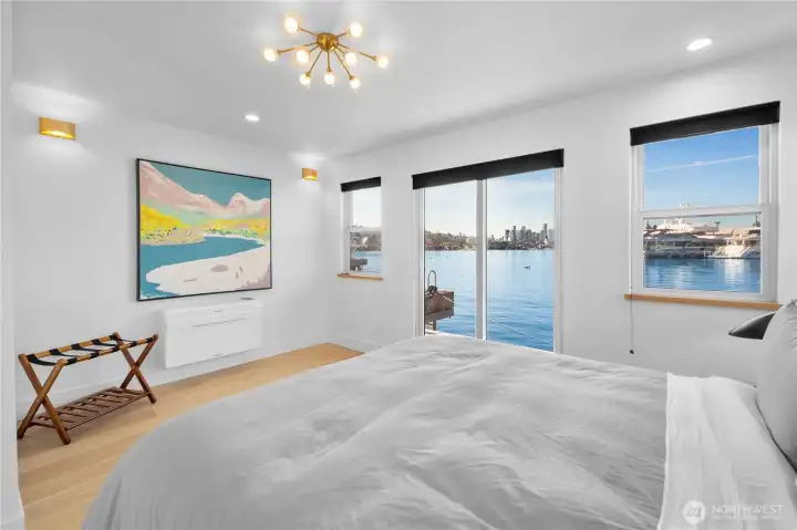 Primary suite on the main level with a lux bath and sliding doors opening to the deck—perfect for a morning dip, paddle board or coffee and croissant over the water.