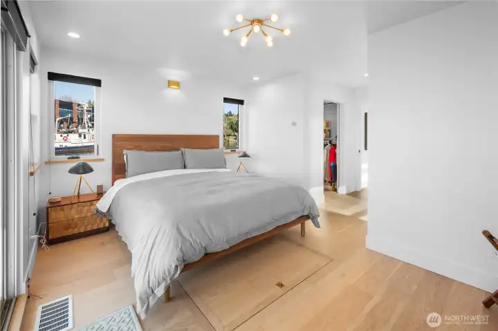 Primary suite on the main level with a lux bath and sliding doors opening to the deck—perfect for a morning dip, paddle board or coffee and croissant over the water.