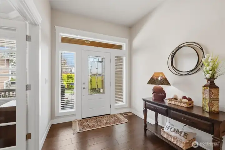 South facing front entry provides warm natural light throughout the entire day. Engineered hardwoods start at the entry and run throughout the hallways, kitchen and formal dining area. Private den is to the left in this picture.