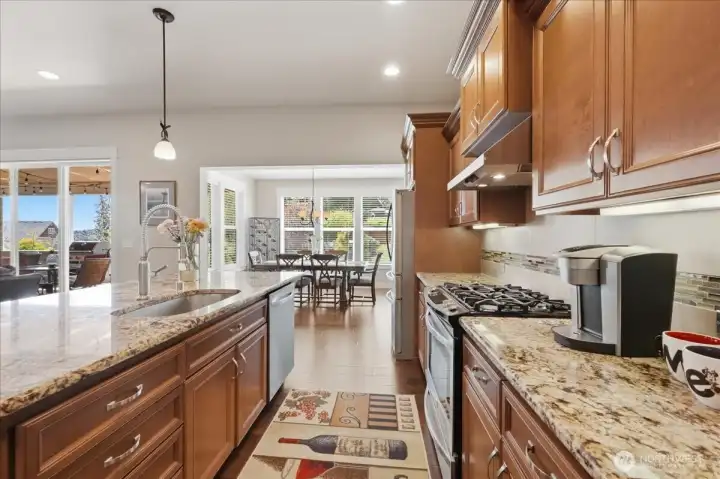 Rounded edge granite countertops, undermount sink, stainless-steel appliances and hardware.  4-burner gas stovetop and gas convection oven. The engineered hardwoods flow to the dining area.