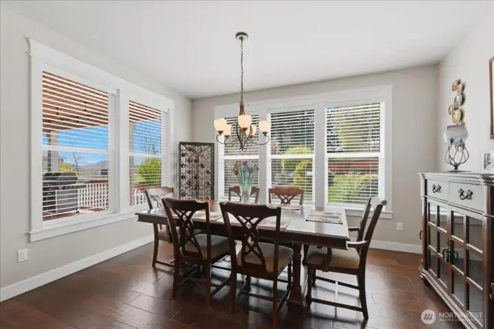 The dining area with views of the covered deck, beautiful landscaped backyard, and mountain view.