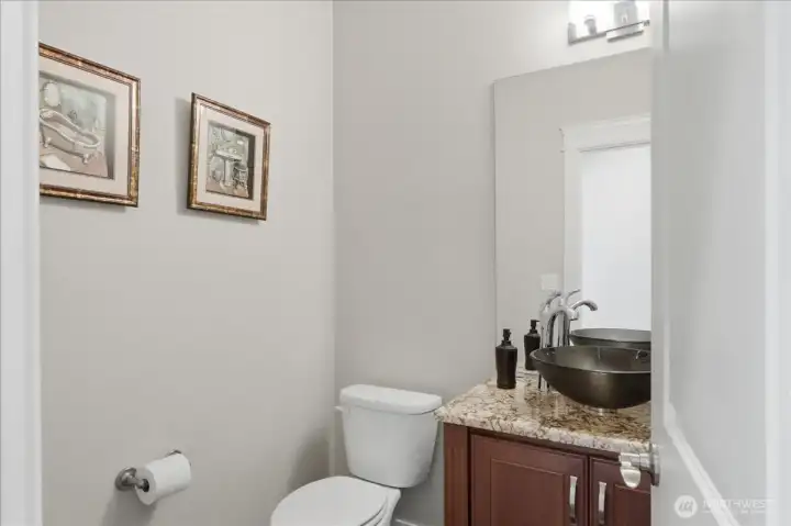 Powder room with granite counter and gorgeous vessel sink.