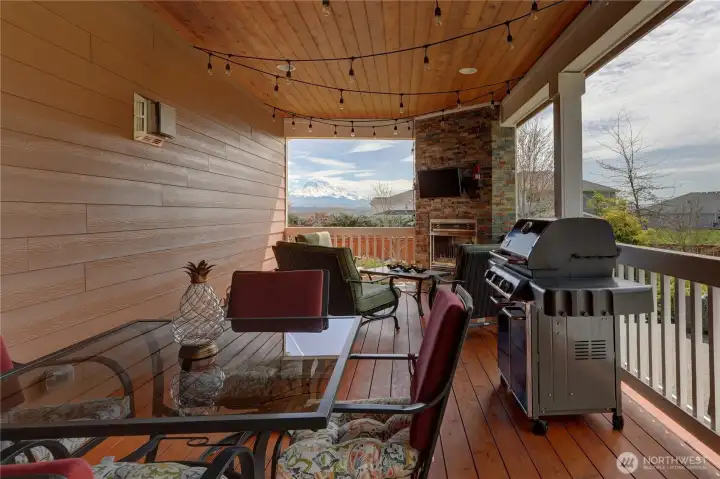 The covered back deck is the perfect spot to enjoy a movie (TV stays), the mountain views, and the gorgeous fully-fenced yard all by the warmth of the gas fireplace.  Notice the tongue and groove ceiling with recessed lighting truly making this an all-season area.