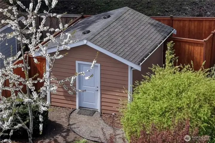 Utility shed has its own fence for additional concealed storage.