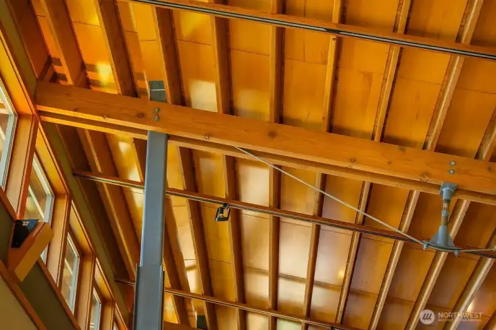 Custom steel inverted king post trusses and exposed wooden roof framing.