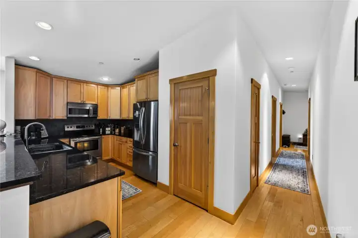 View shows the interior hallway into the home into the great room living space. Pantry storage is just off the kitchen.