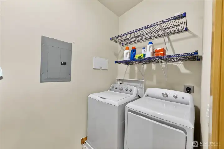Oversized utility with washer/dryer and additional storage behind the door.