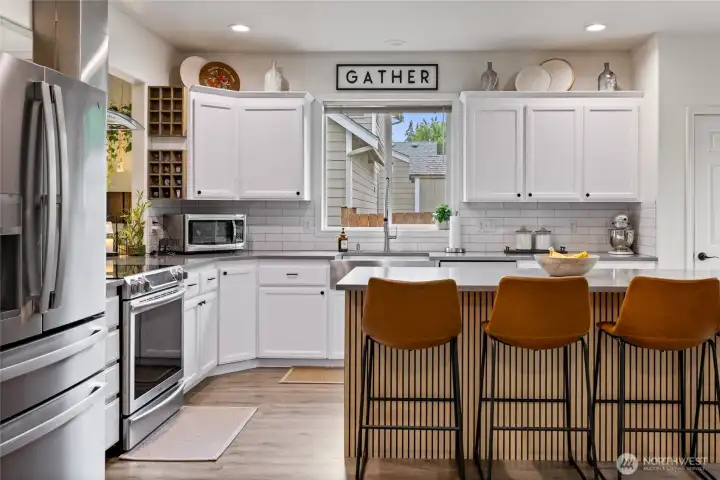 The bright and inviting kitchen serves as the heart of the home, offering abundant workspace, thoughtful updates, and seamless connection to the surrounding living areas.