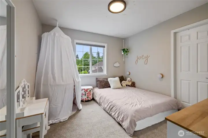 A spacious secondary bedroom with blackout blinds and generous walk-in closet space.