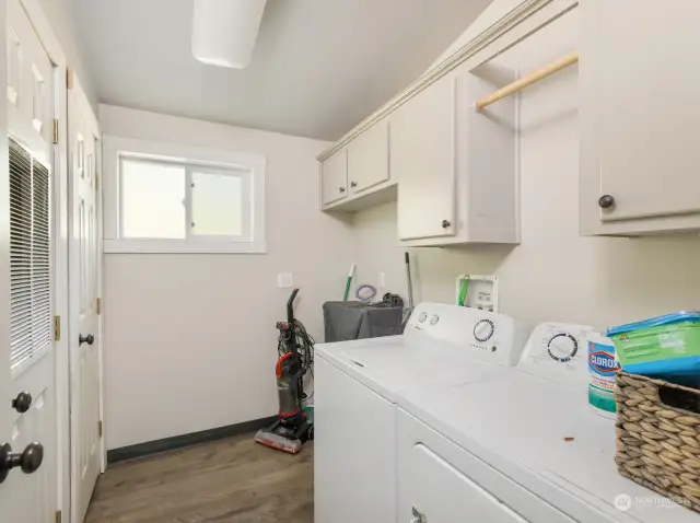 Utility room with full sized washer and dryer.