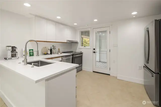 Downstairs, find options for multigenerational living or rental possibilities thanks to this updated kitchen setup with tile floors, and clever breakfast bar seating on the sink peninsula.