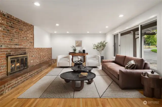 Just inside the entry, find this wonderful living space, complete with vintage brick wood fireplace and brushed-brass-tone built-in glass screen.