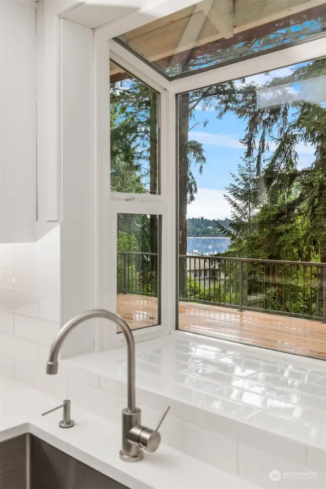 Classic white subway tile frames the garden window in the kitchen, with water views to keep you company while tidying up. A perfect spot to grow your indoor herb garden!