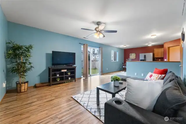 Spacious living room opens to dining and kitchen with sliding door to fully fenced yard