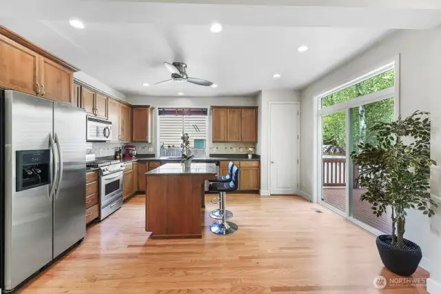 Large kitchen with sitting area and sliding door to the extended deck. This home backs to a lush greenbelt.