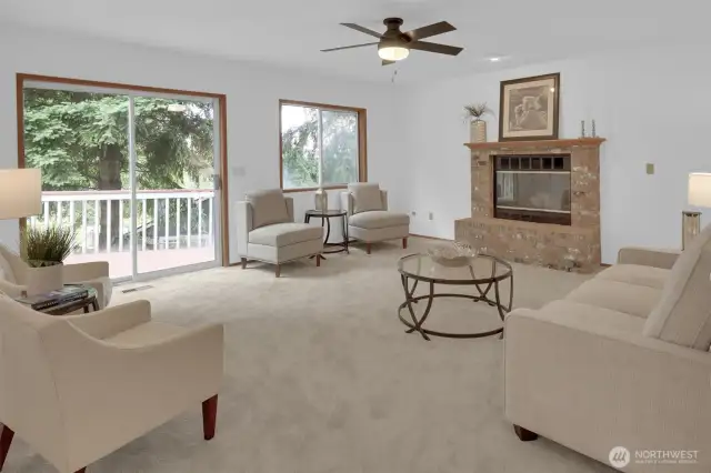 Spacious family room with stately brick fireplace & big sliding door leading out to the deck & backyard