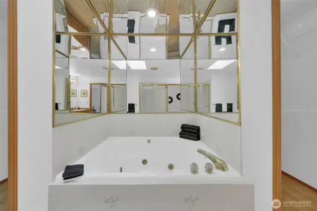 Jetted soaking tub flanked by the walk-in closets