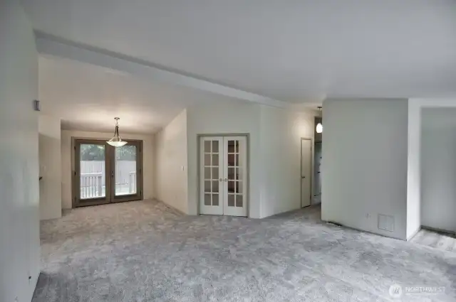Living room view looking towards the den with french doors and the dining area. Did I mention there is new flooring throughout!