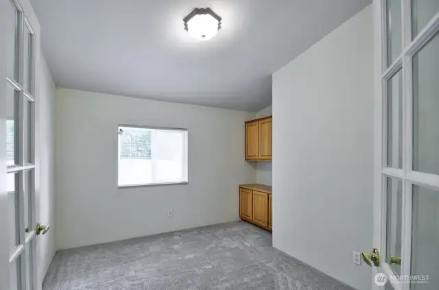 Den/office with glass french doors includes a nice built in desk with storage