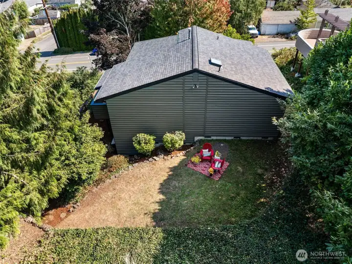 An aerial view of the backyard highlights the generous outline of the level portion of the yard and the lush privacy landscaping.