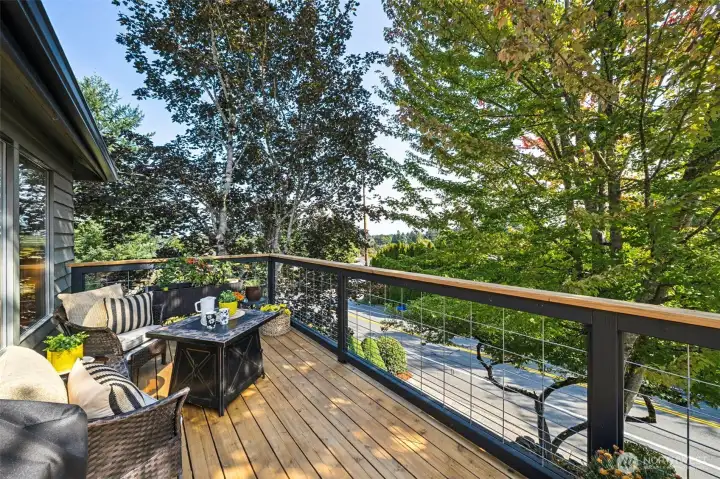 The original deck was removed and a remodeled, contemporary cedar deck with wire and wood railing was added.  Loads of space waits for your grill, container plants or cozy fire table to set the mood for Autumn revelry.