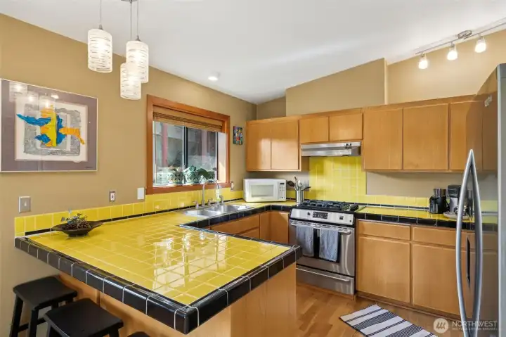 Modern designer tile colors rimmed in black bring the European Style, contemporary wood cabinetry to life.  The duel fuels gas range/electric oven, newer dishwasher and refrigerator are all included.