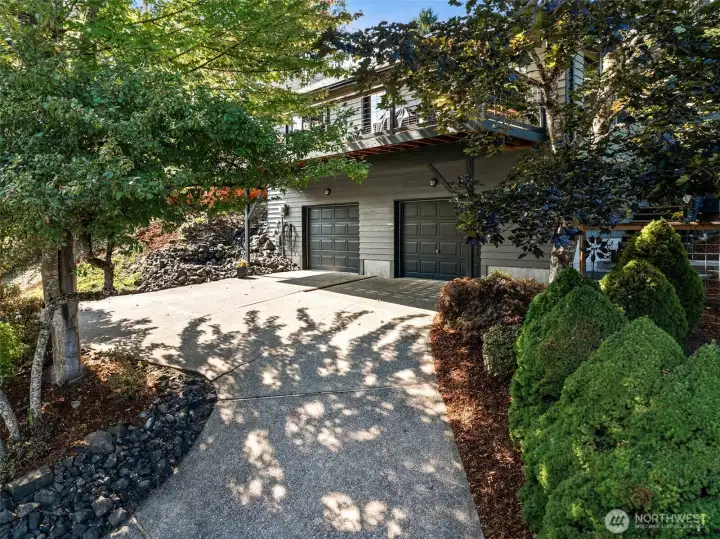 The front of the home rises up to the two car garage with an easy turn around for cars that are parked in the garage. Lovely landscaping lines the drive.