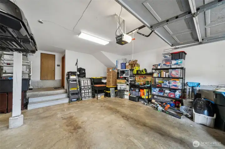 The second garage bay offers loads of high wall space for your workbench or shop items.  The large door in the background leads to the extra wide and tall crawl space with the door to the home to the right of it.