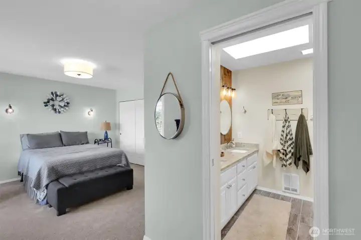 Relax in this private primary bedroom with views of the lake.