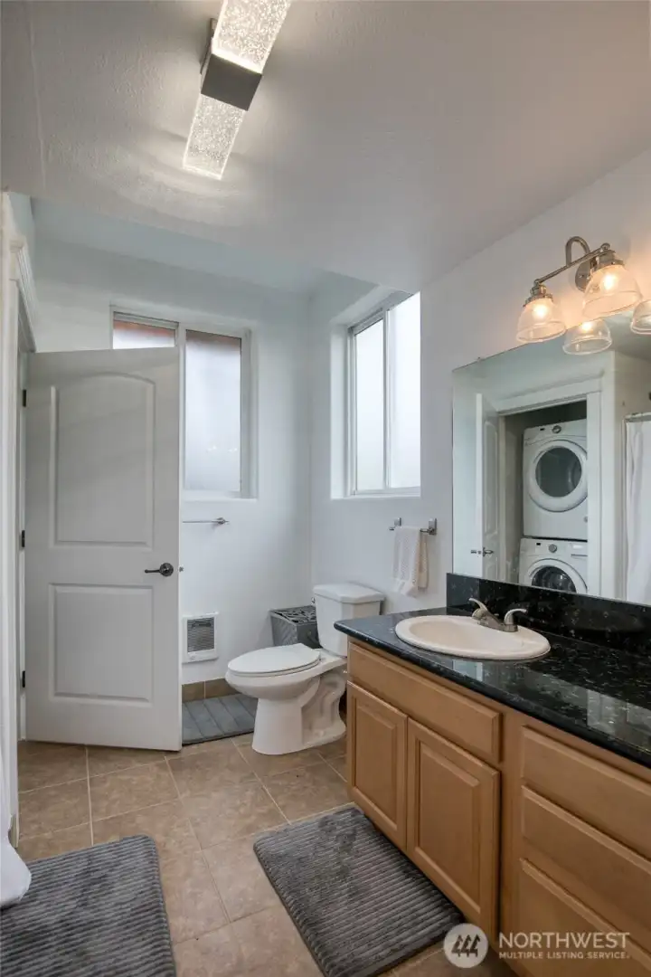 Stackable laundry is also located in the bathroom.