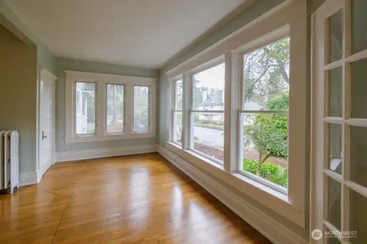 Gorgeous parlor with french doors, original movable mantle, and wall of bookcases.